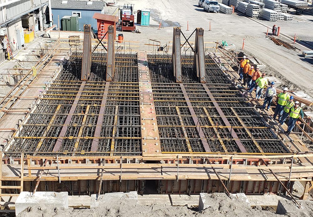 Crew preparing reinforced concrete foundation for structural and site development work