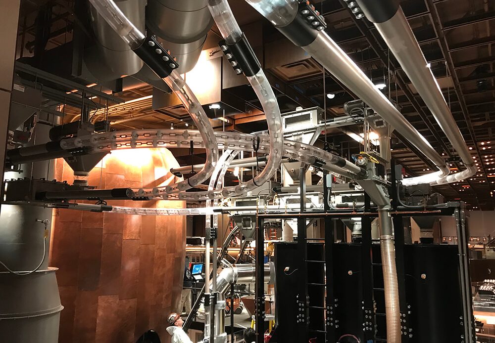 Food and Beverage Processing Systems Stainless steel piping and conveyor systems inside a food and beverage processing facility